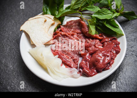 Set di carne fetta di manzo Fegato e Verdure a fungo sulla piastra bianca per cotto o Sukiyaki shabushabu cibi giapponesi cucina Asiatica / Carni bovine fresche materie Foto Stock