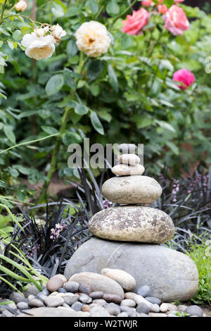 Zen pietre impilate. Ciottoli rotondi impilati uno sull'altro in ordine decrescente di dimensioni. Foto Stock
