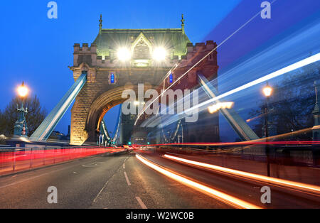 Veicoli che passano oltre il Tower Bridge sul fiume Tamigi a Londra, Regno Unito. Foto Stock