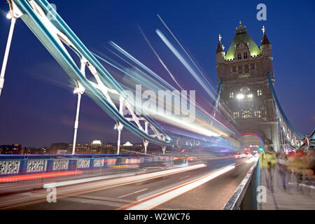 Veicoli che passano oltre il Tower Bridge sul fiume Tamigi a Londra, Regno Unito. Foto Stock