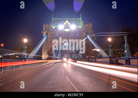 Veicoli che passano oltre il Tower Bridge sul fiume Tamigi a Londra, Regno Unito. Foto Stock