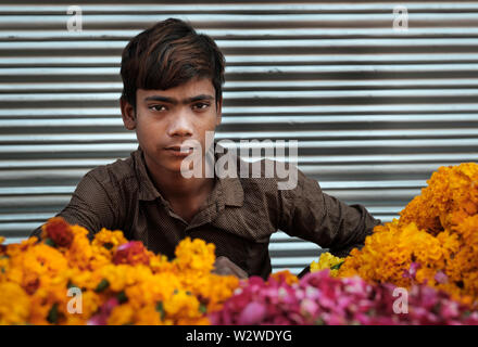 NEW DELHI, India - CIRCA NOVEMBRE 2018: Giovane ragazzo in vendita fiori di tagete in Chandni Chowk area nella vecchia Delhi. Foto Stock