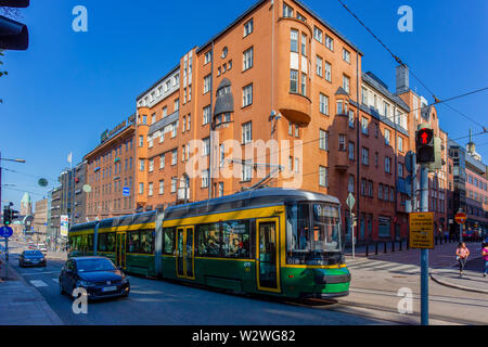 Helsinki, Finlandia - 12 Luglio 2018: una macchina di cavo transita attraverso la splendida capitale della Finlandia. Helsinki Stazione Ferroviaria Centrale è a distanza. Foto Stock