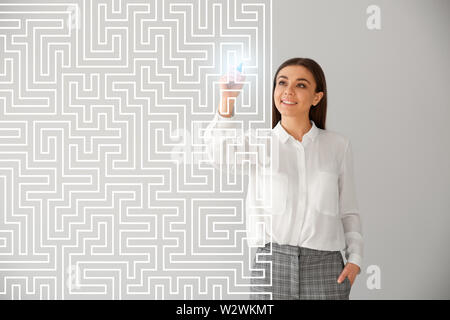 Donna in abiti formali disegno su schermo virtuale contro la luce dello sfondo. Concetto di sviluppo di business plan Foto Stock