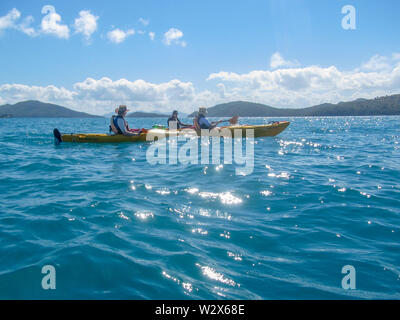 Tre adulti in kayak oceanici in acqua nel NSW, Australia Foto Stock