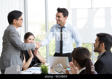 Stretta di mano tra il CEO di esteri e asiatici al manager che è in grado di completare correttamente il progetto che rende la società guadagnare profitti da l annuale Foto Stock