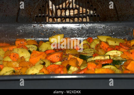 Forno cotto verdure grigliate e croccanti vegetariane e vegane forno verdure condita con erbe aromatiche e olio di oliva Foto Stock