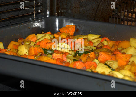 All'interno del forno con forno cotto verdure come guarnire, croccante grigliate vegetariane e vegane forno verdure condita con erbe aromatiche e olio di oliva Foto Stock