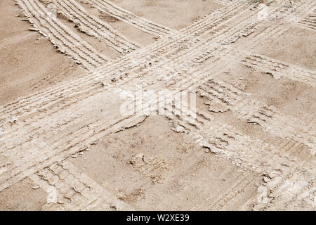 Tracce di pneumatici su bagnato terreno sabbioso, off-road trasporto texture di sfondo Foto Stock