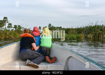 Madre di due bambini piccoli con giubbotti di salvataggio a guardare gli animali in una barca, Parco Nazionale di Esteros del Ibera, provincia di Corrientes, Argentina Foto Stock