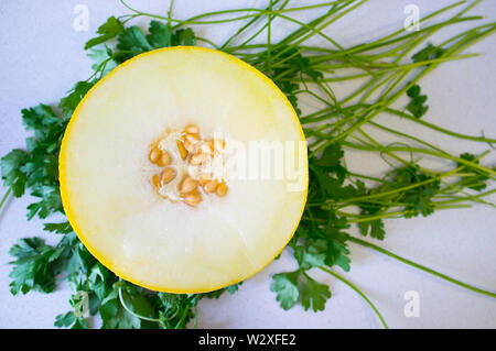 Aprire halff di Melone Galia più fresco e verde sullo sfondo di prezzemolo. Scatto dall'alto Foto Stock