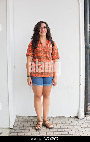 Caucasian woman standing all'angolo della piazza, Bournemouth, Regno Unito, con un informale spiaggia comoda vacanza stile di moda Foto Stock