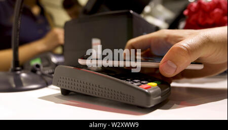 Uomo paga il suo telefono in negozio Foto Stock