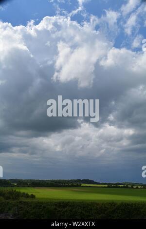 paesaggio di grandi nuvole sui campi sulla costa dell'Inghilterra. Foto Stock