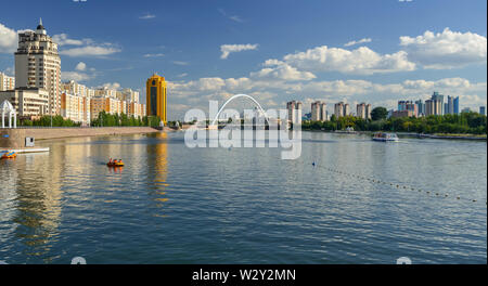 Quay del fiume Ishim ad Astana. Ponte 'Karaotkel' (Ramstore). /Astana, Kazakistan - 1 Settembre 2013: persone ride su imbarcazioni da diporto e catamarano Foto Stock