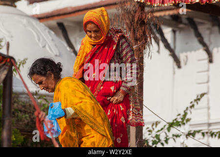 Due donne anziane lasciando un tempio a Kathmandu dopo la preghiera Foto Stock