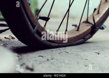 Incredibile close up vecchio anteriore di bicicletta di antica casa, la ruota di bicicletta la ruggine, danneggiata con sfondo sfocato in tono vintage a China Town, Vietnam Foto Stock