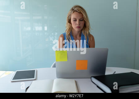 Imprenditrice lavorando sul computer portatile alla scrivania in ufficio Foto Stock
