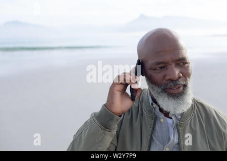 Afro-americano di uomo che parla al telefono in spiaggia Foto Stock