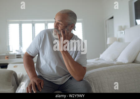 Uomo seduto sul letto Foto Stock