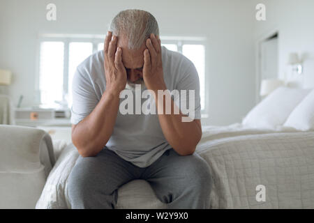 Uomo seduto sul letto Foto Stock
