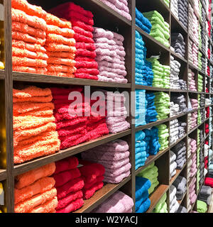 Terry asciugamani colorati sugli scaffali in negozio vendita Foto Stock