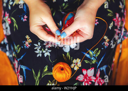 Le mani delle donne crochet. Fatti a mano, ricamo e hobby. Close-up, vista dall'alto. Tonica. Foto Stock