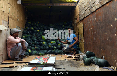 New Delhi, India. 11 Luglio, 2019. Due uomini vendere angurie in un frutto mercato all'ingrosso a Nuova Delhi, in India, il 11 luglio 2019. Credito: Zhang Naijie/Xinhua/Alamy Live News Foto Stock