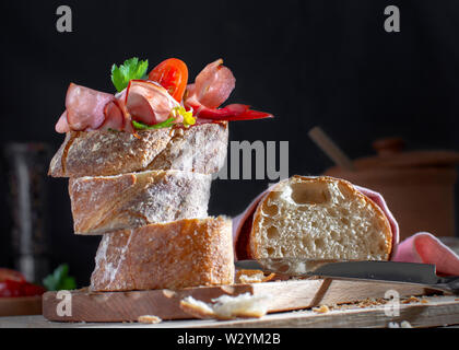 Breadtime con al filone di pane, salsicce, affettati e sottaceti pomodori burro e noci Foto Stock