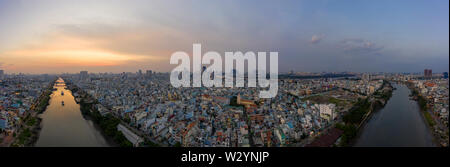 Panorama al tramonto della città di Ho Chi Minh (Saigon) Vietnam dal distretto 7 con canal e area residenziale in primo piano e dello skyline della città in background Foto Stock