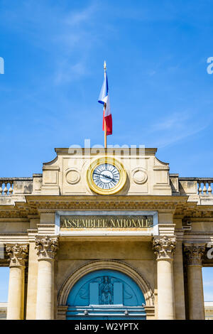 Close-up di Frontone con orologio e bandiera dell'entrata sud del Palais Bourbon, sede dell'Assemblea nazionale francese a Parigi, Francia. Foto Stock