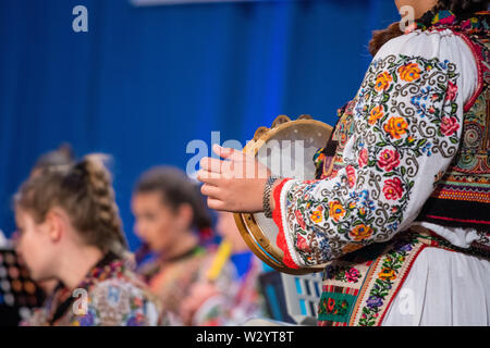 Chiudere fino alle mani del giovane ragazza rumena in tradizionale costume folkloristico. Il folklore della Romania Foto Stock