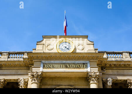 Close-up di Frontone con orologio e bandiera dell'entrata sud del Palais Bourbon, sede dell'Assemblea nazionale francese a Parigi, Francia. Foto Stock