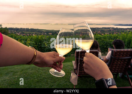 Fare un brindisi in un vigneto bar con una bella vista prima del tramonto Foto Stock