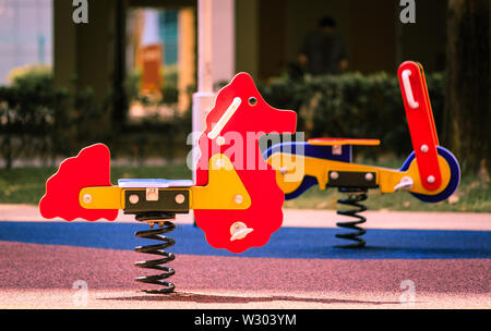 Swing cavallo giocattolo per bambini su un parco giochi per bambini Foto Stock