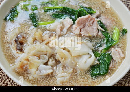 Saltate in padella grande noodle con carne di maiale in salsa di salsa sul piatto Foto Stock