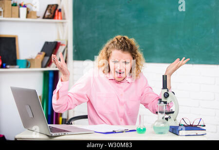 Femmina emotiva formatori d insegnanti in aula lavagna sfondo. Persone emotive del concetto. Donna tutor o studente alla scrivania con computer portatile e attrezzature scolastiche articoli di cancelleria. Controllo emotivo. Foto Stock