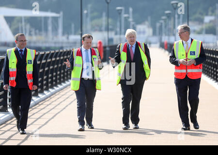 Direzione del Partito conservatore candidato Boris Johnson le passeggiate con il dover MP Charlie Elphicke (seconda a sinistra), e Doug Bannister, chief executive officer del porto di Dover Ltd (a destra) durante una visita al porto di Dover Ltd, Kent, mentre sul sentiero di campagna. Foto Stock