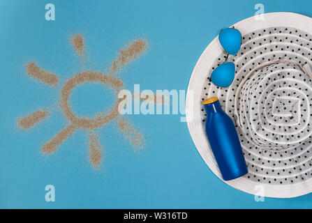 Dipinto di sun, cappello, crema solare e occhiali da sole su sfondo blu. Vista dall'alto. Tema la spiaggia su sfondo blu. Foto Stock
