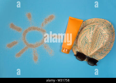 Dipinto di sun, cappello, crema solare e occhiali da sole su sfondo blu. Vista dall'alto. Tema la spiaggia su sfondo blu. Foto Stock