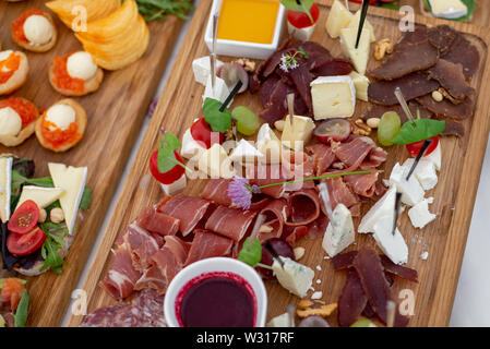 Grande selezione di cibo con spuntini freddi, insalate, carne fredda, formaggio e marmellata servita. Varietà di gustosi spuntini deliziosi sul tavolo. Ricevimento di nozze Foto Stock