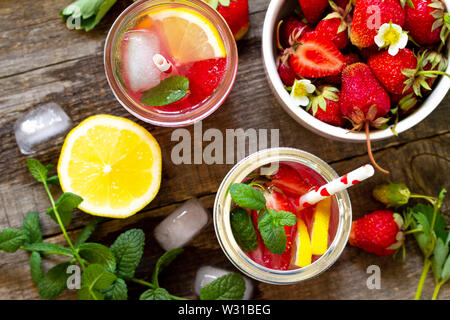 Fragole fresche limonata su tavola in legno rustico. Vista superiore piatta sullo sfondo dei laici. Foto Stock