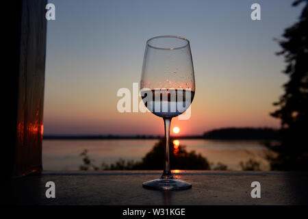 Bicchiere di vino al tramonto. Barnes Isola, Maine. Fuori del collo Harpswell. Penobscot Bay. Oceano Atlantico. Foto Stock