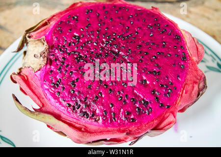 Affettato aperto dragonfruit con carne rossa e semi Foto Stock