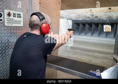 Maschio di turisti britannici sparare pistola a vuoto alla gamma di pistola Orlando Florida USA Stati Uniti d'America Foto Stock