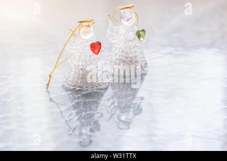 Due angeli in vetro con cuori sul tavolo Foto Stock