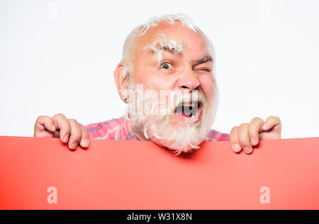 Spazio copia placare le informazioni. Hai bisogno di aiuto. barbiere. Senior uomo barbuto luogo annuncio su banner. scioccato uomo maturo con piume capelli grigi. Annuncio di ciò che sta accadendo. Foto Stock