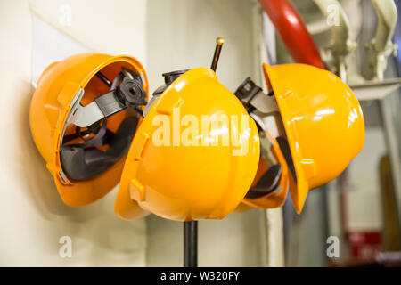 Giallo di sicurezza hardhats indossare il casco appeso su un appendiabiti Foto Stock