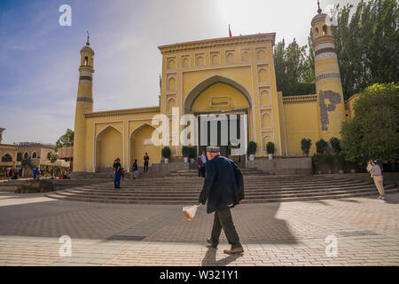 Kashgar, Cina. Xix Apr, 2019. Un anziano etica Uyghur uomo cammina davanti alla Moschea Id Kah e a Kashgar. La provincia dello Xinjiang si trova nella parte nord occidentale della Cina è la più grande provincia in Cina. La maggior parte della popolazione è di religione musulmana nello Xinjiang. Recentemente il governo cinese ha imposto una massiccia repressione di sicurezza nello Xinjiang, dove più di un milione di etnia uiguri e altri per la maggior parte delle minoranze musulmane sono creduti per essere mantenuto in una rete di internamento che Pechino descrive come ''istruzione professionale " centri " destinata a persone dello sterzo lontano da religiosi extre Foto Stock