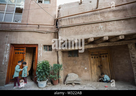 Kashgar, Cina. Xix Apr, 2019. I bambini si vedono giocare al di fuori del loro tradizionale stile uigura casa nel centro storico della città vecchia di Kashgar. La provincia dello Xinjiang si trova nella parte nord occidentale della Cina è la più grande provincia in Cina. La maggior parte della popolazione è di religione musulmana nello Xinjiang. Recentemente il governo cinese ha imposto una massiccia repressione di sicurezza nello Xinjiang, dove più di un milione di etnia uiguri e altri per la maggior parte delle minoranze musulmane sono creduti per essere mantenuto in una rete di internamento che Pechino descrive come ''istruzione professionale " centri " destinata a peopl dello sterzo Foto Stock